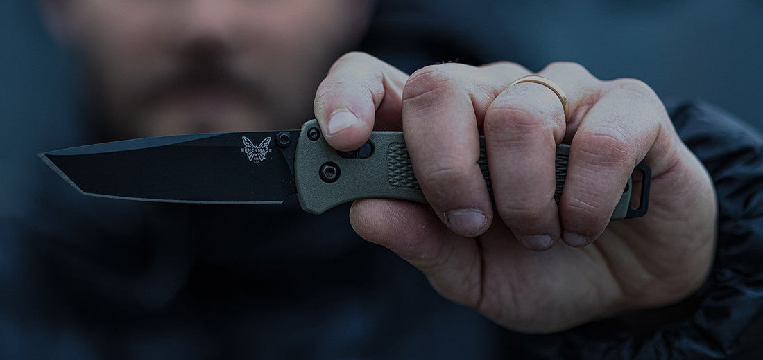 Hand gripping a Benchmade folding knife with olive handle and black blade, showcasing premium build for your next EDC upgrade.