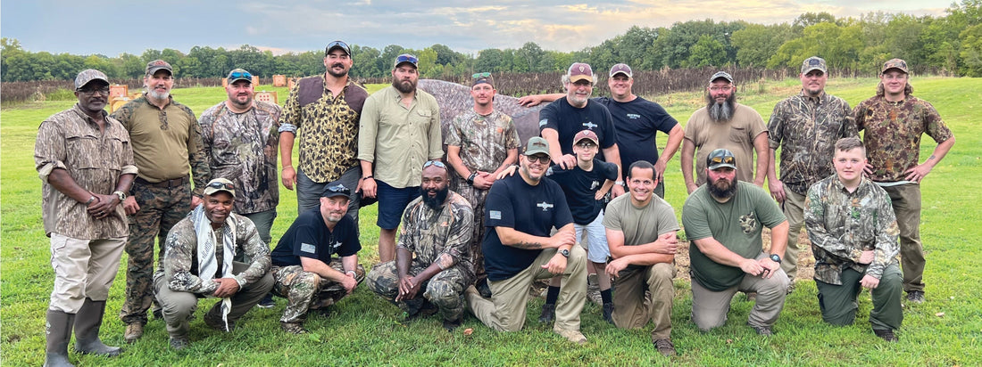 Diverse group of hunters in camouflage posing together outdoors, embodying strength and camaraderie within their community.