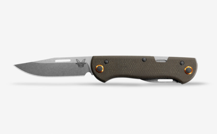 Open folding knife with gray blade, olive green textured handle, orange pivot rings, and butterfly logo on white background.