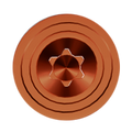 Copper thumb lug with hexagonal center and concentric rings, top-down view.